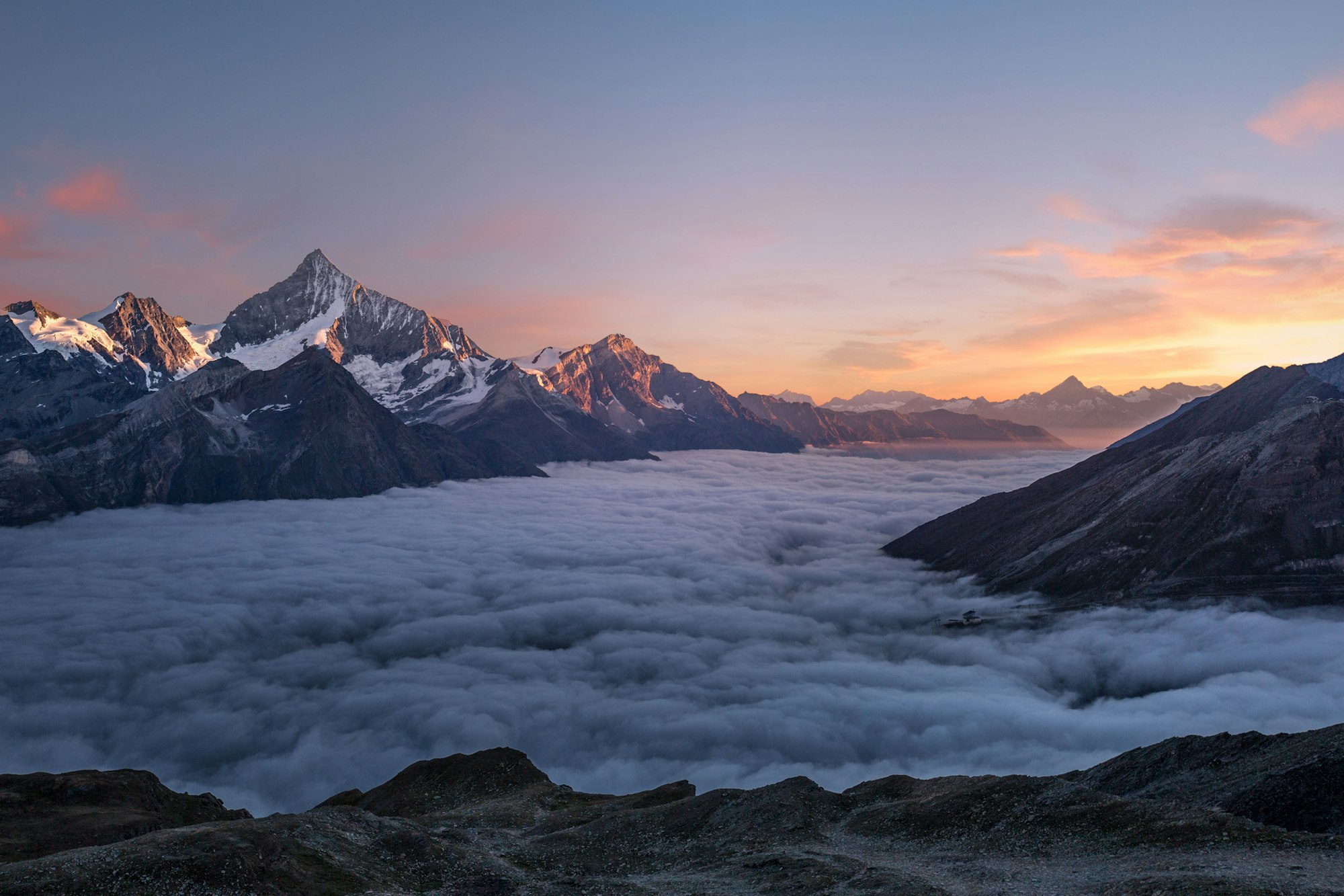 Wanderer above the sea of fog - mountain peak in clouds